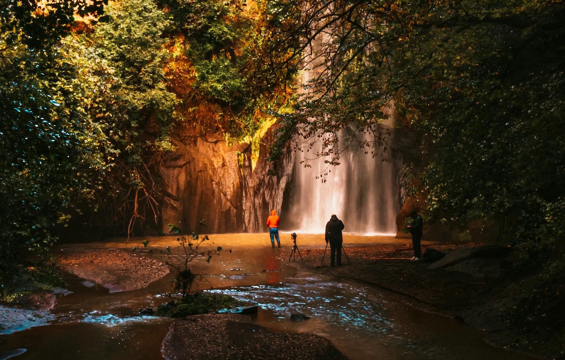 people standing near a waterfalls