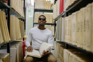 a blind man in a white sweater reading braille